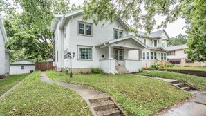 A two-story house with a front porch, a pathway leading to the front door, and a small front yard.