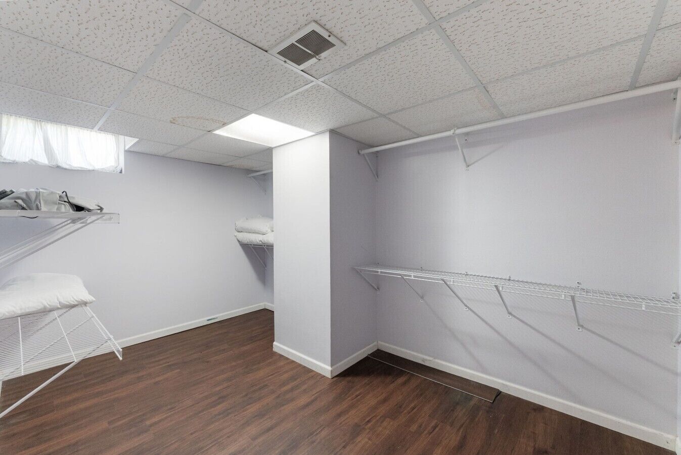 A room with a bunk bed, a drying rack, and a shelving unit.