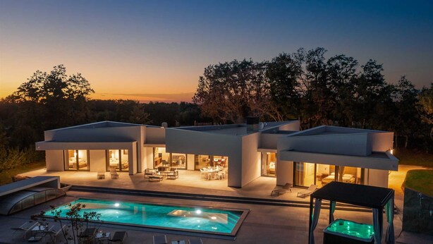 A modern house with a swimming pool, multiple rooms with glass doors, and outdoor seating. - Luxury Villa Mauve with Pool (Režanci)