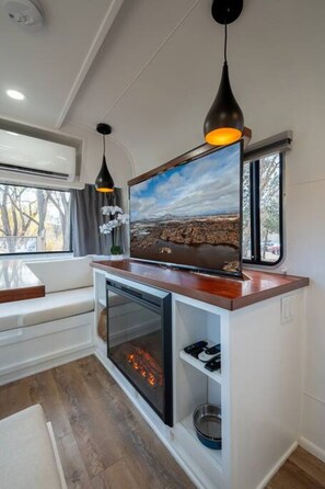 A modern kitchen with a built-in oven, a wooden countertop, and pendant lighting.