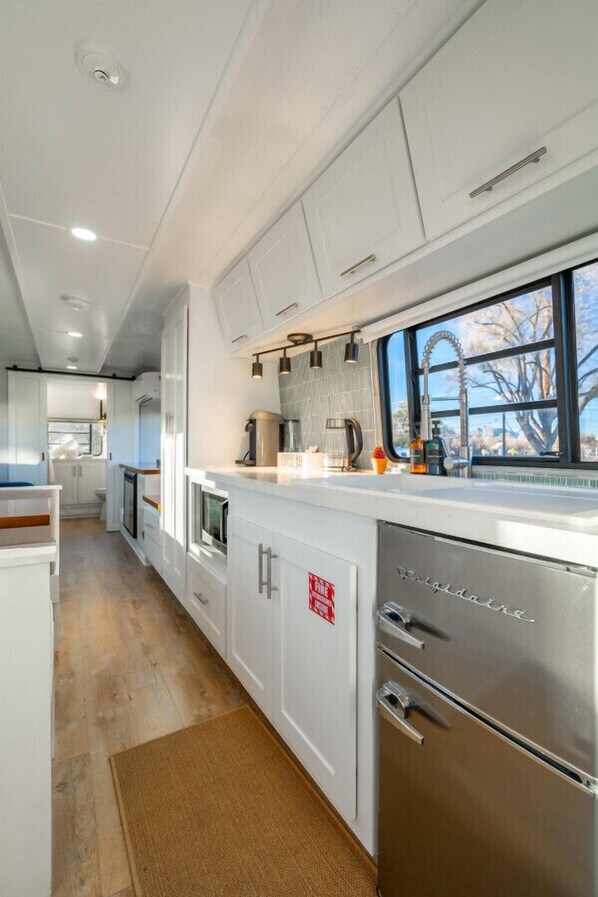 Microwave, coffee/tea maker, cookware/dishes/utensils, dining tables