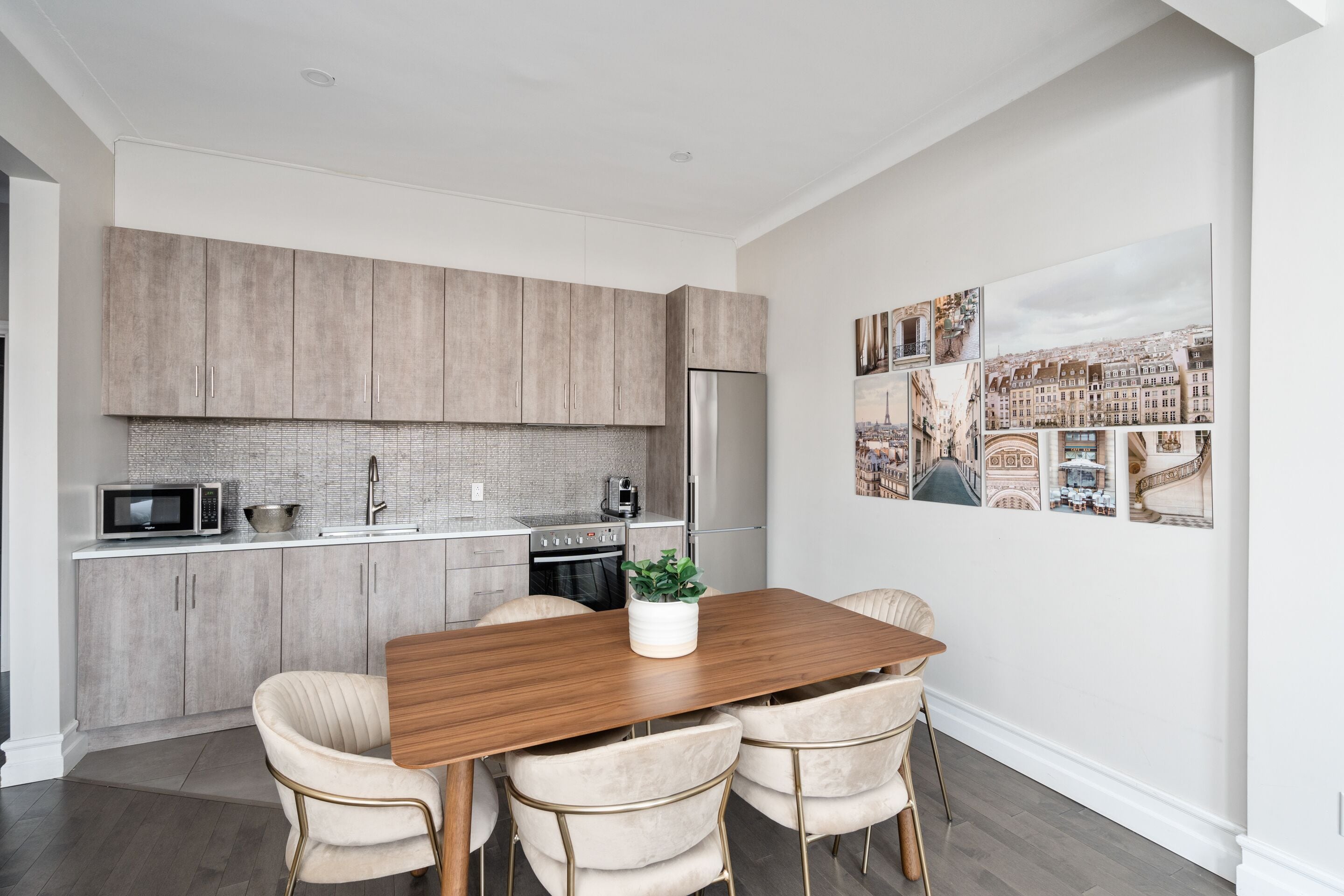 Een moderne keuken met een houten eettafel, vier stoelen en een koelkast.