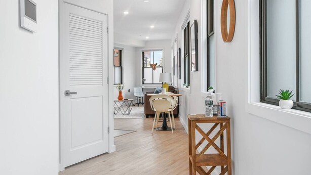 A hallway with a dining area, white walls, and wooden flooring. - ✮Unique 1BR | Walk to NJPAC/NJPENN | 30min to NYC✮ (Newark)