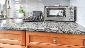 A kitchen with wooden cabinets, a built-in microwave, and a dish rack. - Lavish 3Bed Apt !  Free Gated Parking! 30 min NYC! (newark)