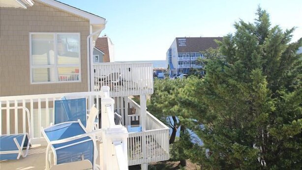 A two-story house with a balcony and a view of the ocean. - Immaculately maintained property just steps to the beach in Dewey Beach. (Dewey Beach)