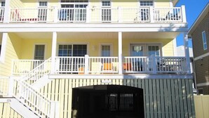 A two-story building with a balcony on each floor, a covered entryway, and a visible garage door. - Immaculately maintained property just steps to the beach in Dewey Beach. (Dewey Beach)