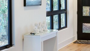 A room with a white desk, large windows, and a black door. - Newly Built Modern Home In CLT! Great Location! (Charlotte)