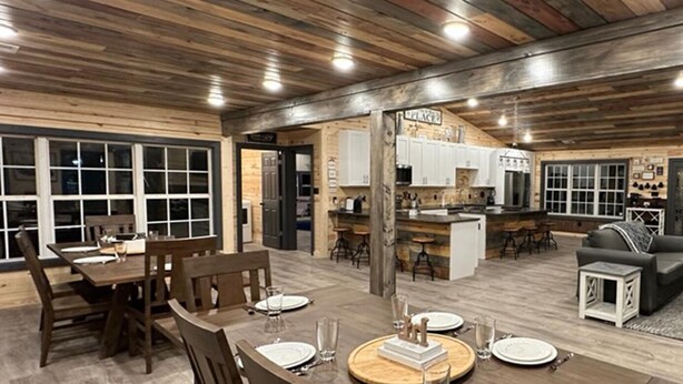 A spacious living area with a dining table set for four, a kitchen with a bar area, and a cozy seating arrangement with sofas and a coffee table. - 5 Bedrooms Pool Theater Arcade Firepit (Sevierville)