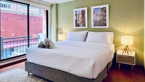 A hotel room with a large bed, two bedside lamps, and two framed pictures on the wall. - Palace by Wynwood House  (Bogotá)