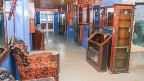 A corridor with antique furniture and mirrors, wooden cabinets, and a tiled floor. - Atlanticoast Residence (Bakau)