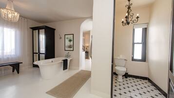 Une salle de bain spacieuse avec une baignoire sur pieds, des toilettes et un meuble-lavabo.