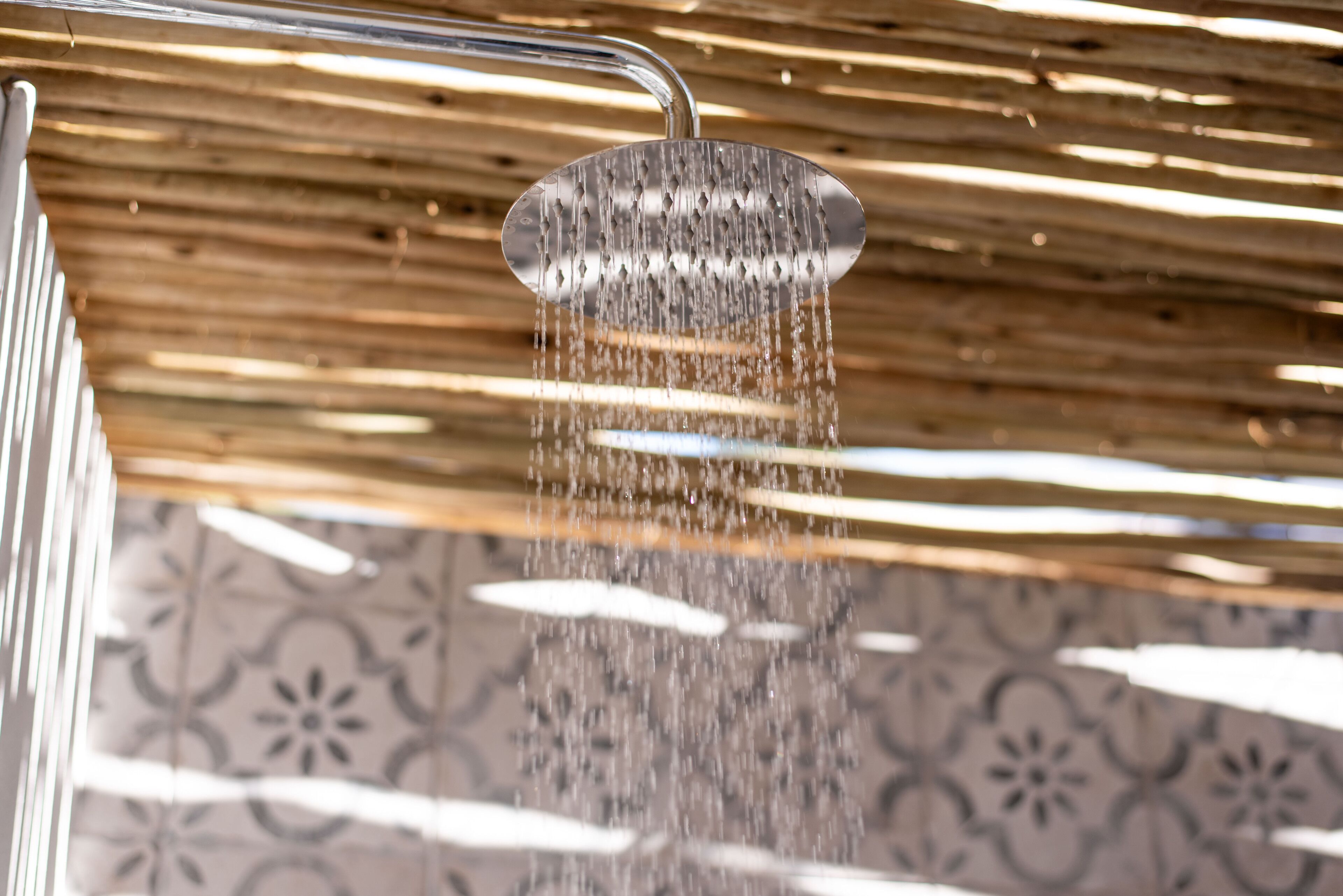 Un pommeau de douche d’où jaillit de l’eau.
