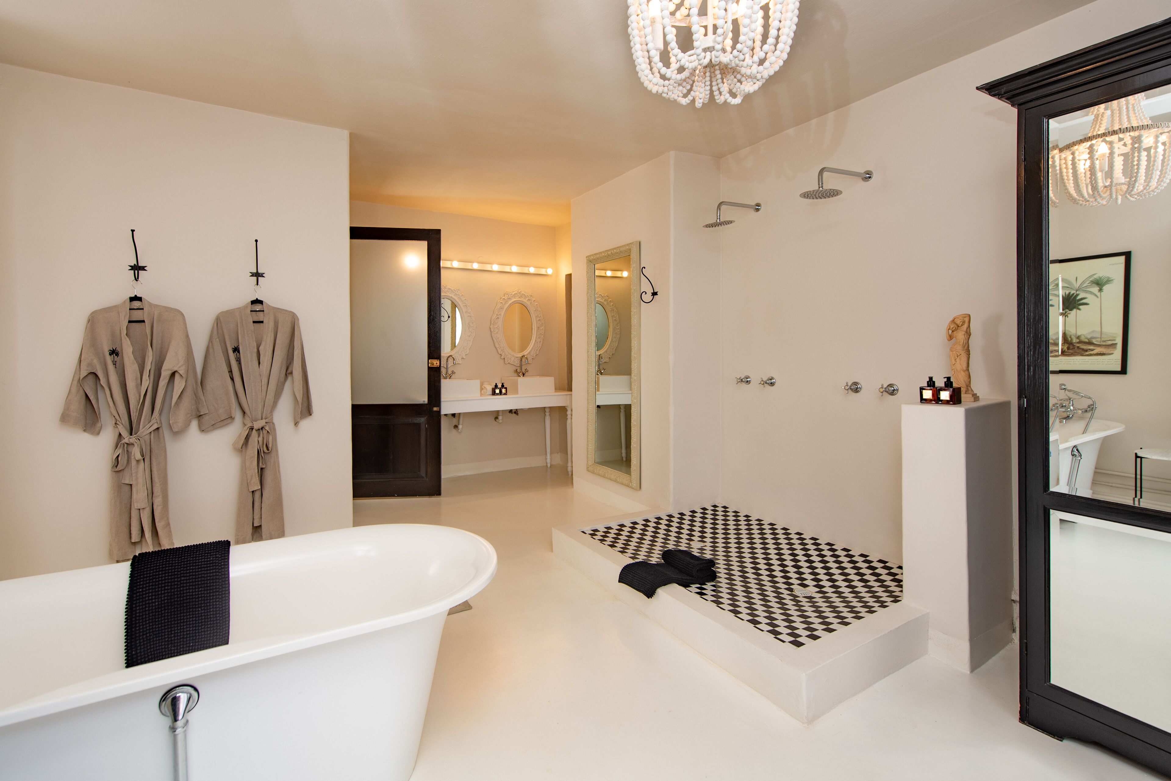 A modern bathroom with a freestanding bathtub, a separate shower area, and a vanity with a mirror.