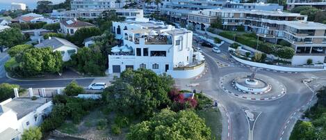 A modern building with a unique architectural design, surrounded by lush greenery and a well-maintained garden.