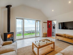 A living room with a fireplace, a sofa, a coffee table, and a TV.