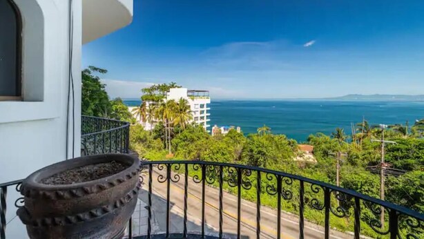 A balcony with a view of the ocean and a building in the background. - Paradise Ocean View Condominium in Puerta Vallarta (Puerto Vallarta)
