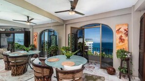 A spacious balcony with a round table and chairs, a ceiling fan, and a view of the ocean. - Paradise Ocean View Condominium in Puerta Vallarta (Puerto Vallarta)