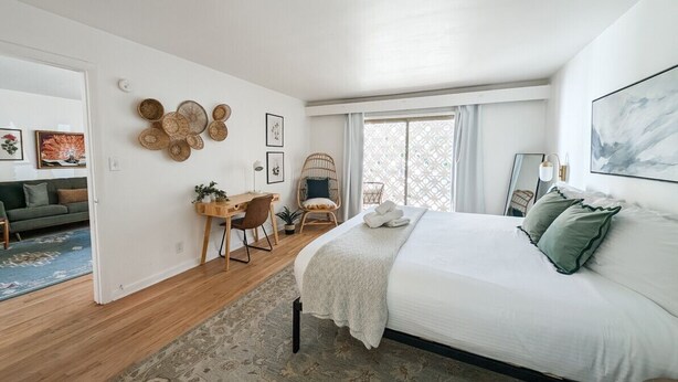 Une chambre à coucher moderne avec un grand lit, un bureau et une chaise.