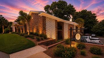 A brick building with a sign for Palm Breeze Suites.