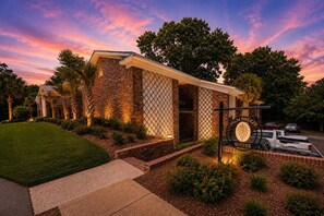 Un edificio de ladrillo con un letrero que dice Palm Breeze Suites.