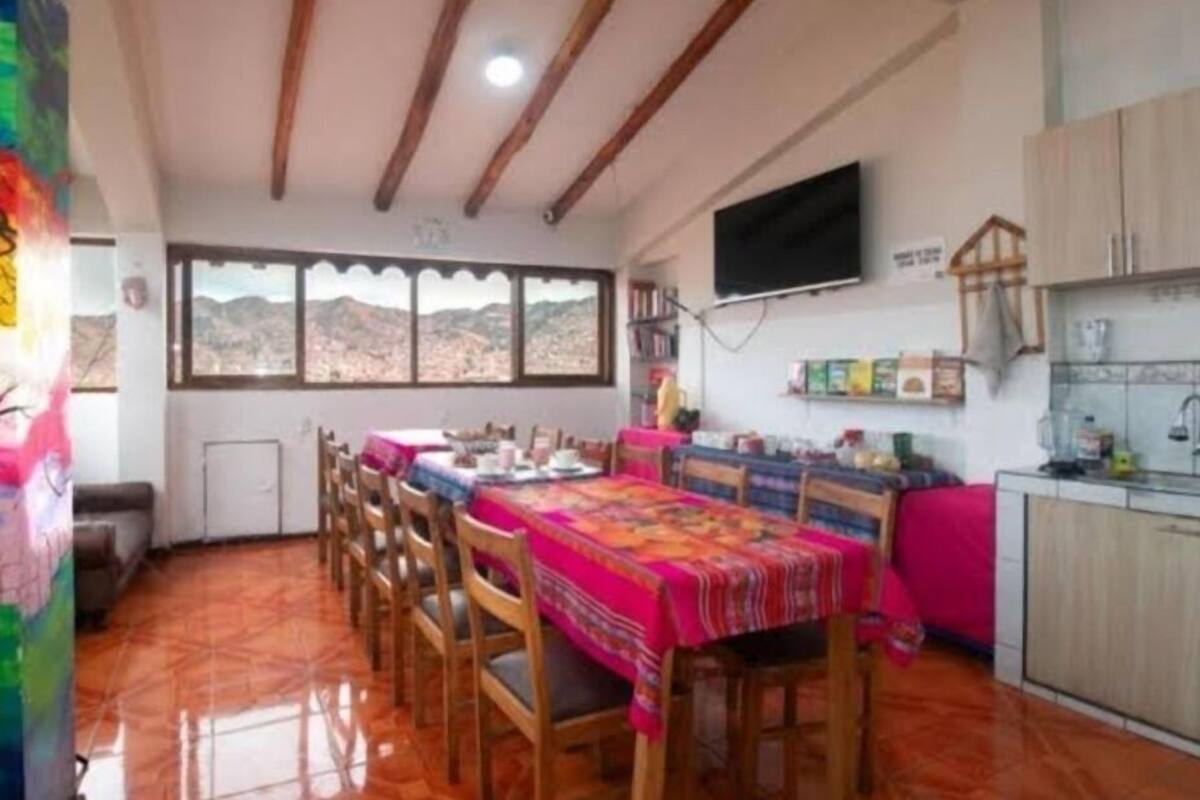 A dining area with a long table, chairs, and a view of the mountains through large windows.