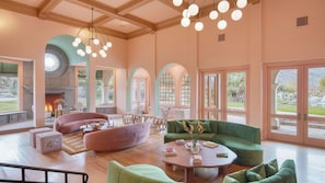 A spacious living area with a fireplace, comfortable seating, and large windows offering views of the outdoors.