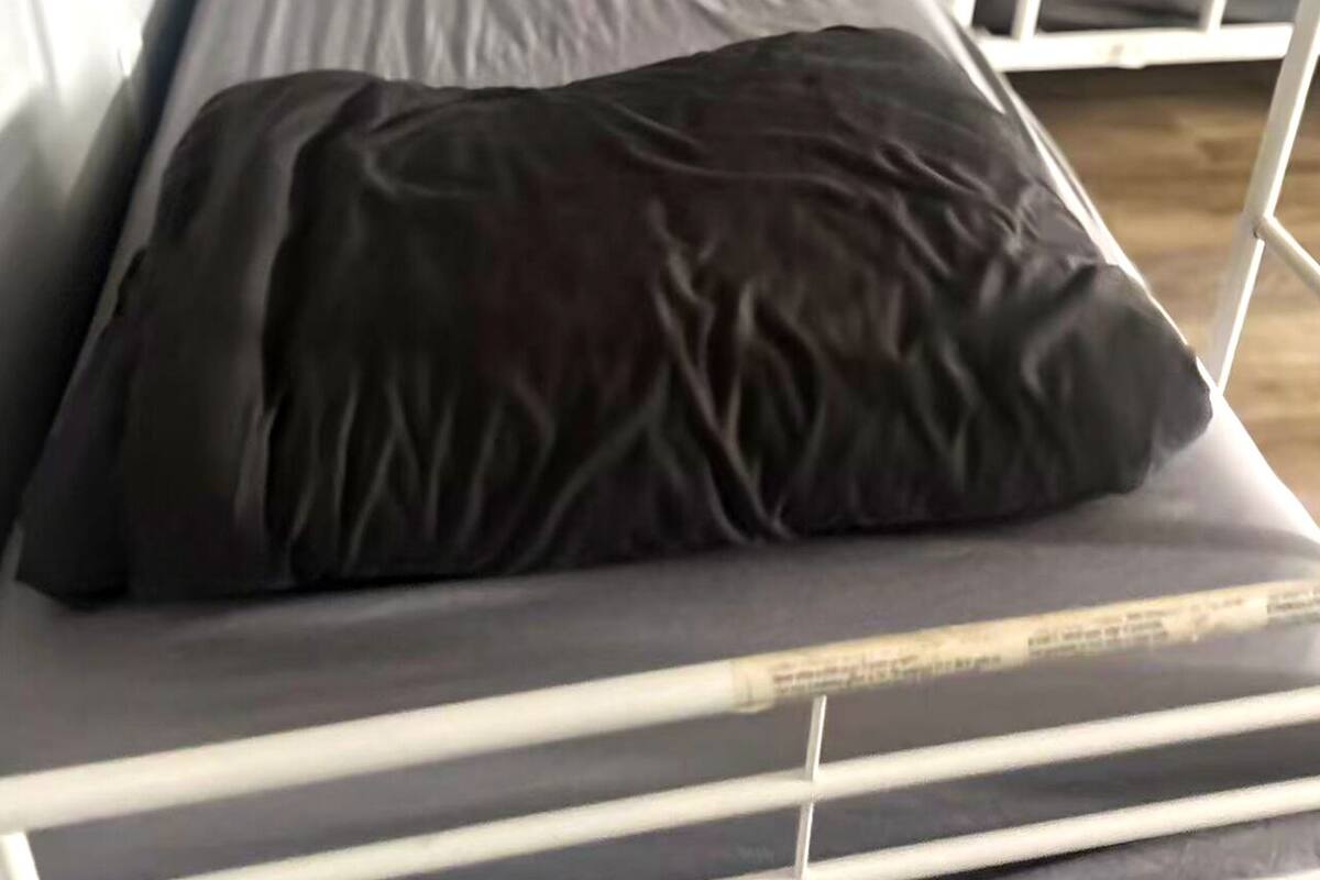 A bunk bed with a mattress and a pillow.