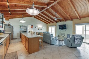A spacious kitchen with wooden cabinets, a central island, and a dining area with chairs.