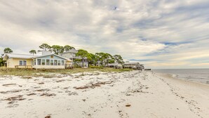A beachside property with multiple houses, a wooden pier, and a sandy beach. - Beachfront Alligator Point Retreat: Steps to Sand! (Alligator Point)
