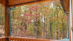 Eine Holzterrasse mit Blick auf Herbstbäume.