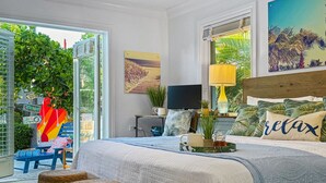 A bedroom with a large bed, a TV, and a view of the outdoors. - Luxury Boating Paradise+Pool+Sailing Kayaks (Marathon)