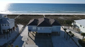 A beachfront property with a large house, a smaller house, and a beach view.