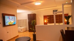 Een moderne hotellobby met een receptiebalie, een zithoek en een zichtbare spa-ruimte op de achtergrond.