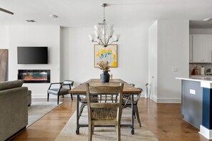 Cozy living space with a dining area, flat-screen TV, and fireplace, perfect for relaxing and socializing.
