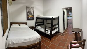 A single room with a bed, a bunk bed, a small table, and a chair. - HOTEL CAMPESTRE LAS PALOMAS (Tocaima)