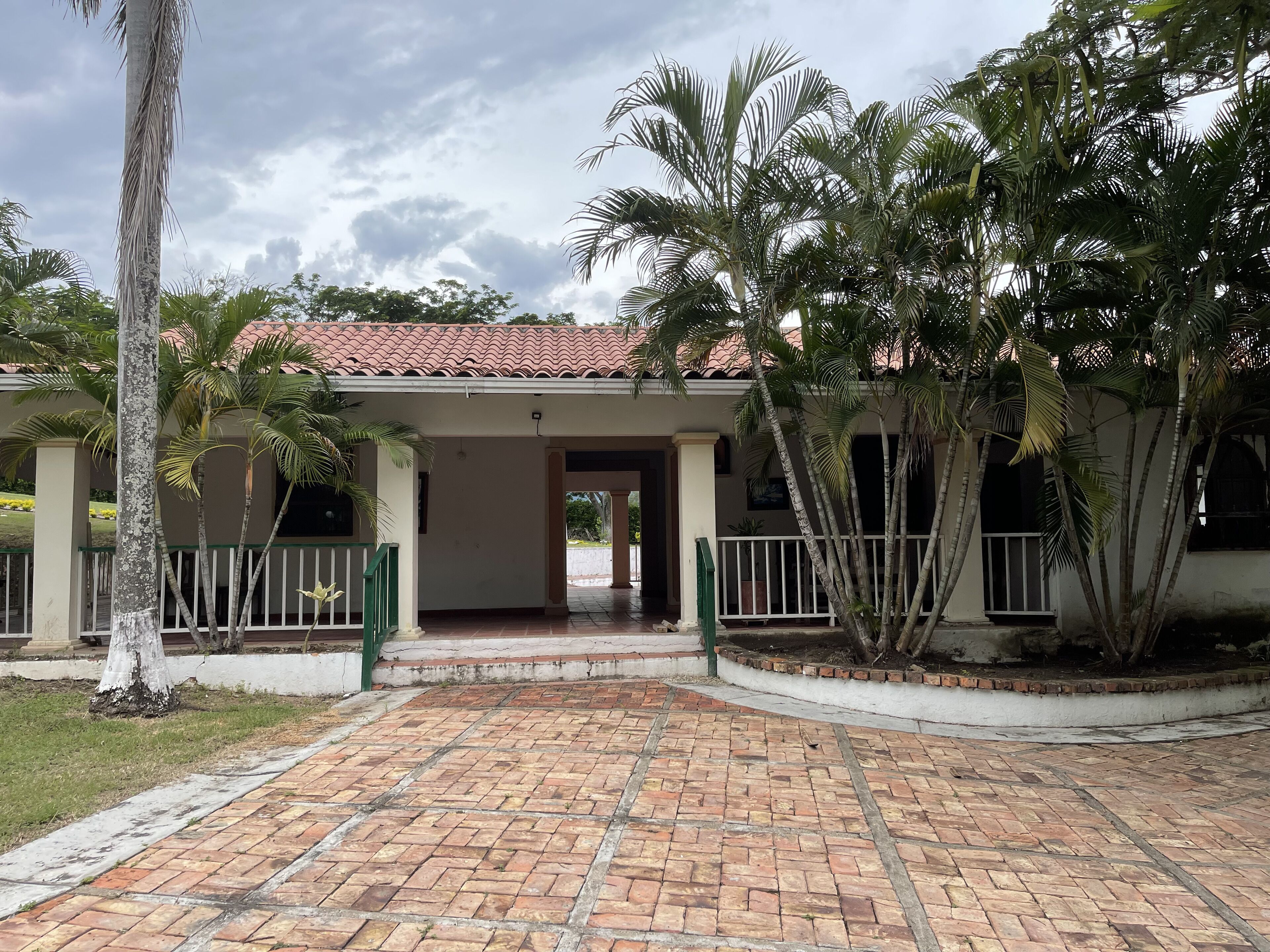 Um edifício com telhado telhado e área de entrada pavimentada.