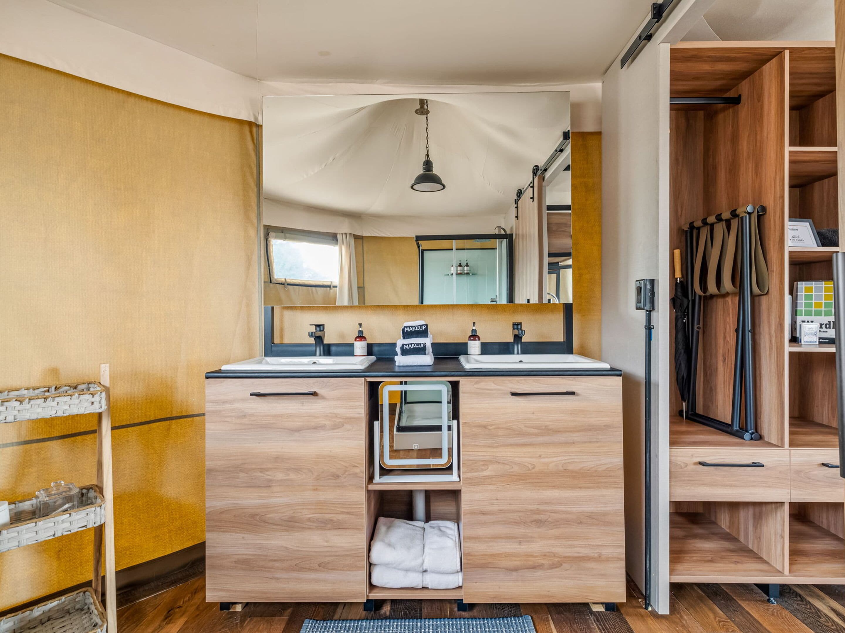 Une salle de bain moderne avec un meuble-lavabo en bois, deux vasques et un grand miroir.