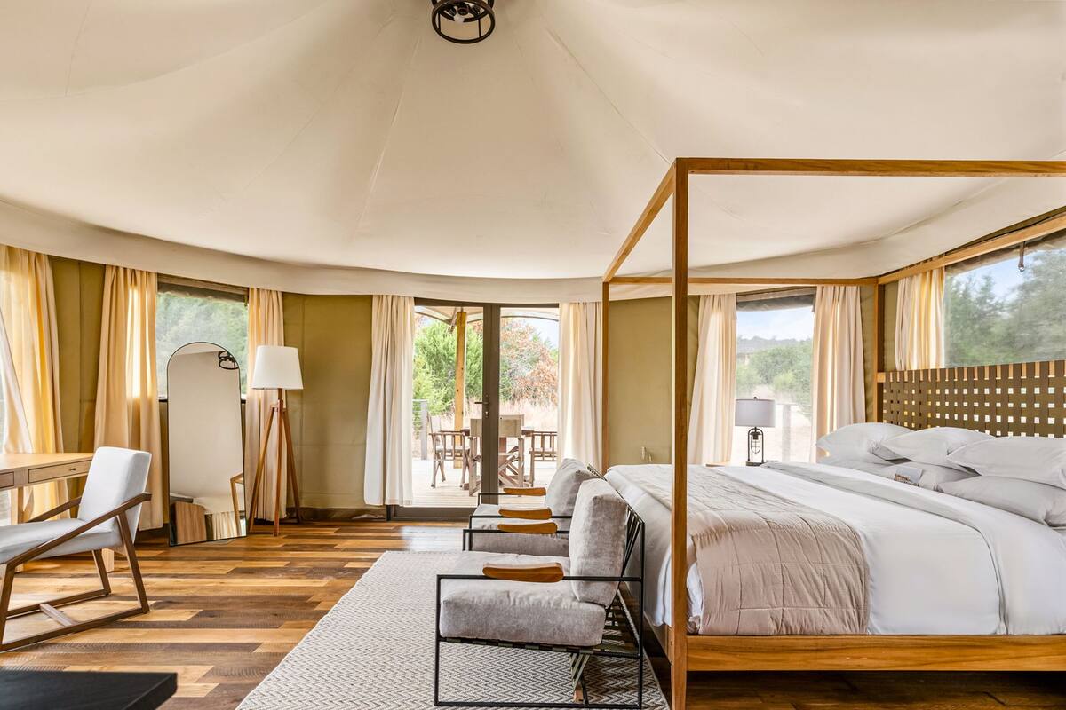 Une chambre spacieuse avec un lit à baldaquin, un bureau et une chaise.