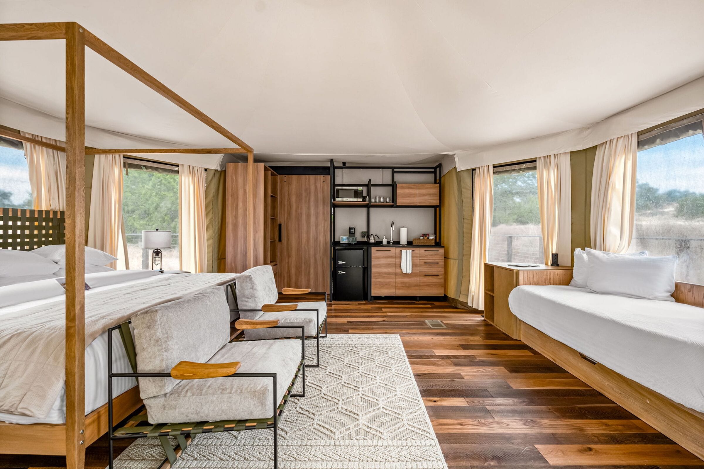 Una habitación moderna con cama, sofá, escritorio y zona de cocina.