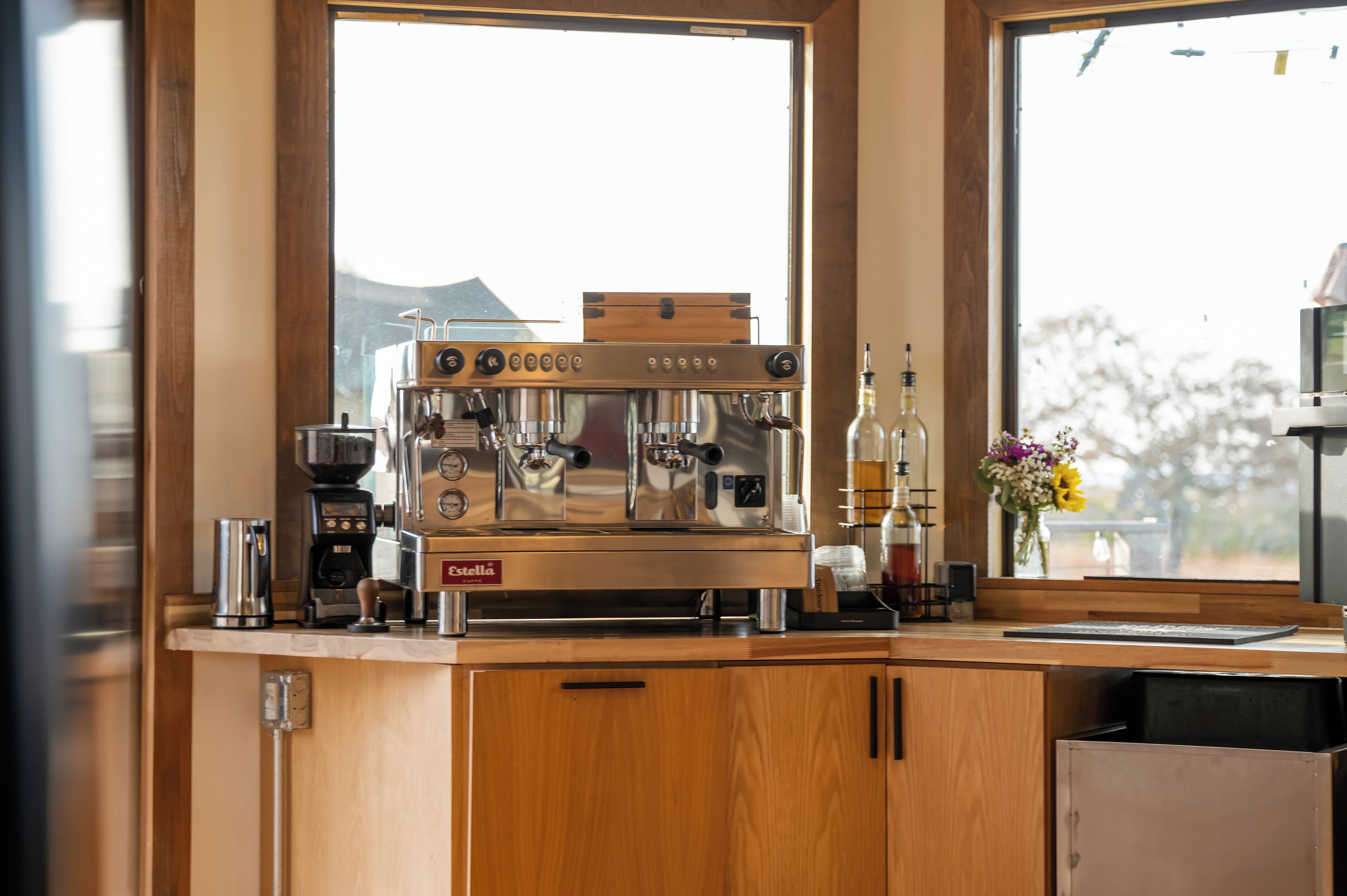 Een koffieapparaat op een houten aanrecht, met uitzicht op een raam.