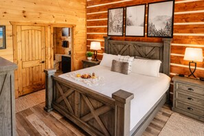 A wooden cabin-style bedroom with a bed, bedside tables, a dresser, and a door. - Free Dollywood Tix/Luxe/Spacious/Modern/Game Room (Gatlinburg)