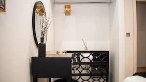 A small, modern bathroom with a black vanity, a mirror, a sink, and a decorative vase with branches.