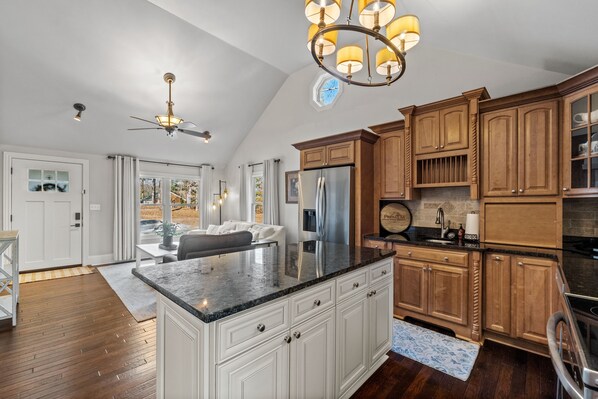 A spacious kitchen with wooden cabinets, a large island, and a built-in refrigerator.