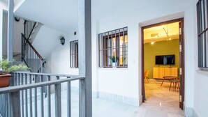 A modern interior with a staircase, a dining area, and a TV in a room. - Lifestyle Sweet Home (Sevilla)