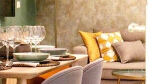A dining area with a table set for a meal, a sofa with cushions, and a floor lamp. - Lifestyle Sweet Home (Sevilla)