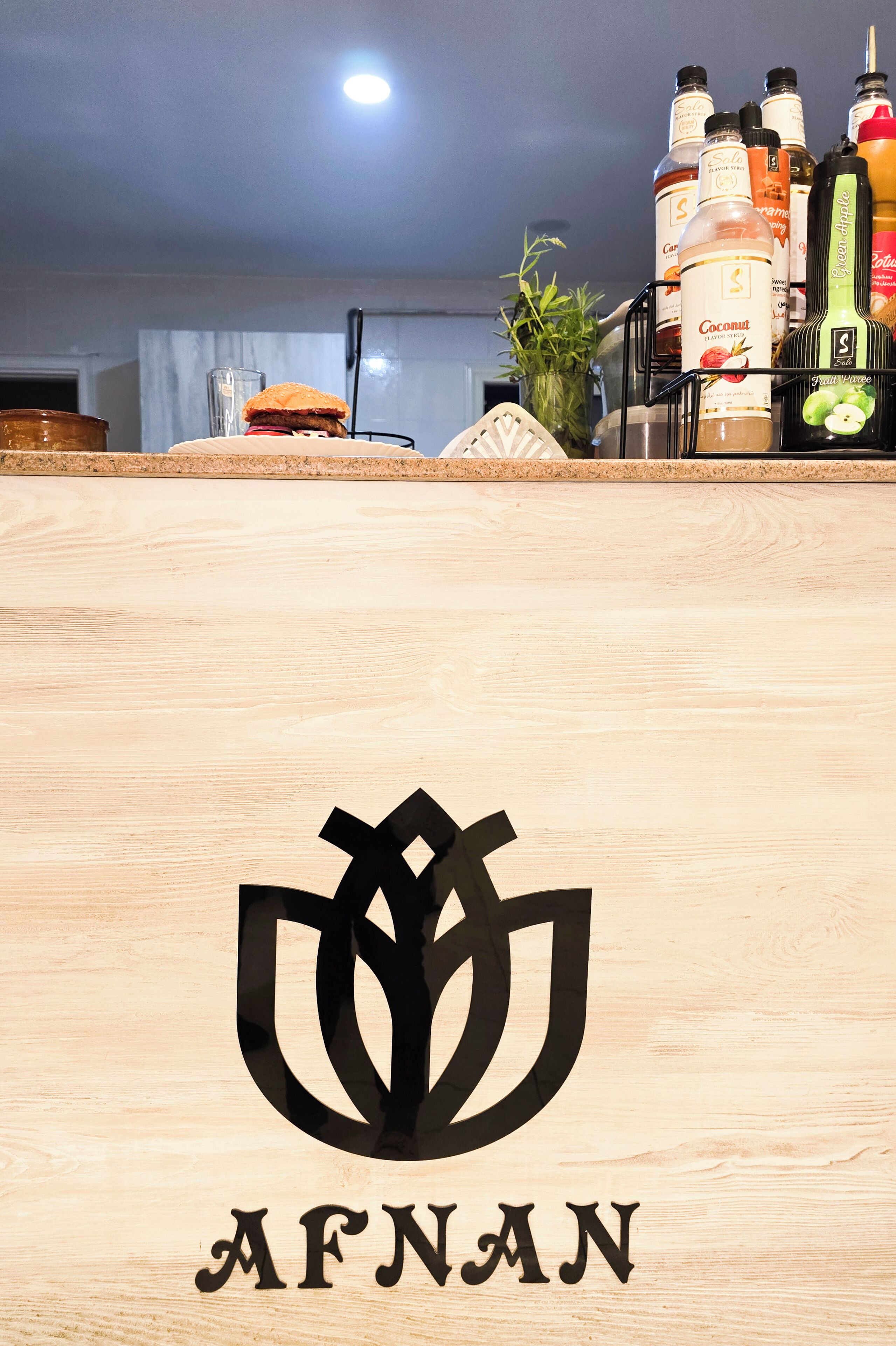A wooden surface with a logo and the name "AFNAN" on it.