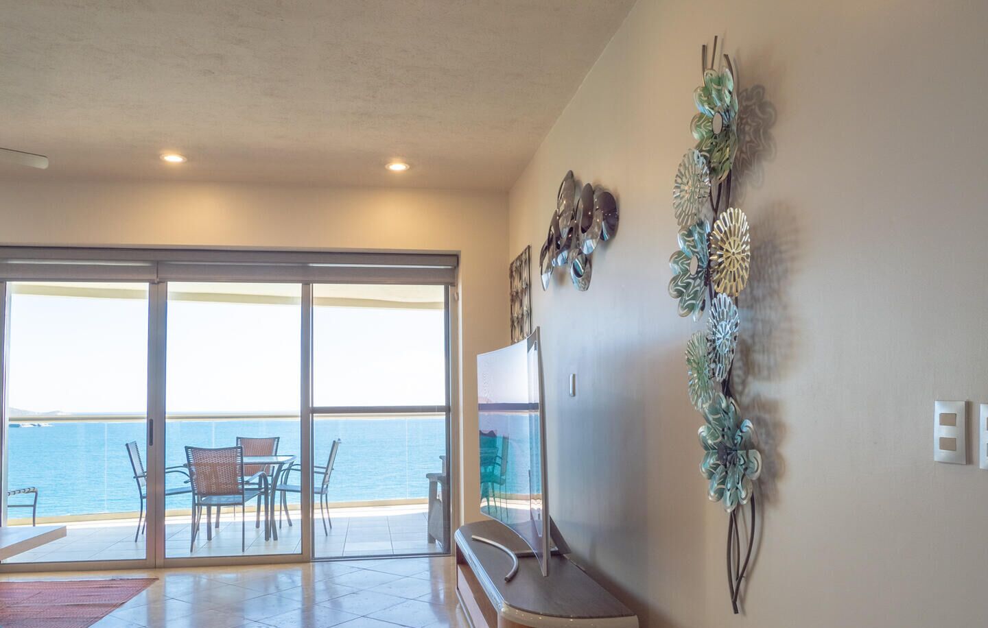 Quarto com porta de vidro deslizante que dá para uma varanda com vista para o mar.