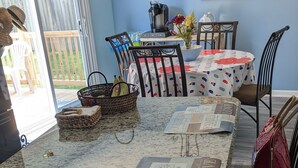 Una cocina con encimera de granito, una isla de madera y una zona de comedor con mantel a cuadros.