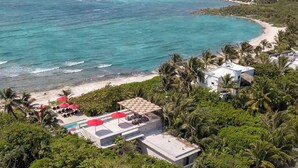 Ein Resort mit Poolbereich, Zugang zum Strand und üppiger Bepflanzung.