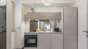 Una cocina moderna con horno empotrado, cocina a gas y refrigerador.